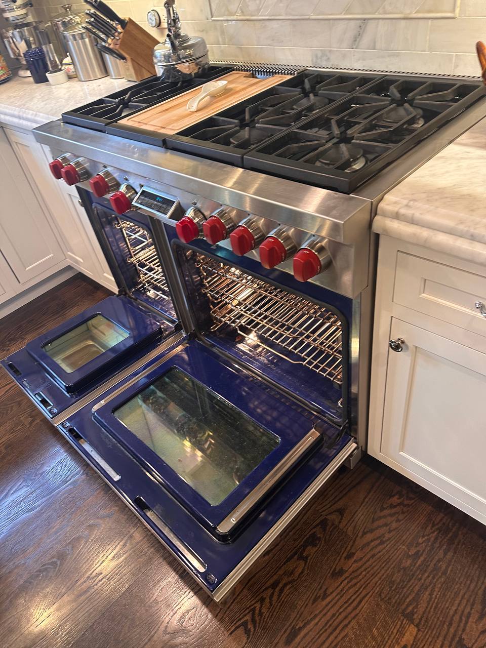 Sub-Zero appliance repair in Miami — Wolf dual-fuel pro range mid-service in a luxury Miami kitchen &mdash; sister brand of Sub-Zero